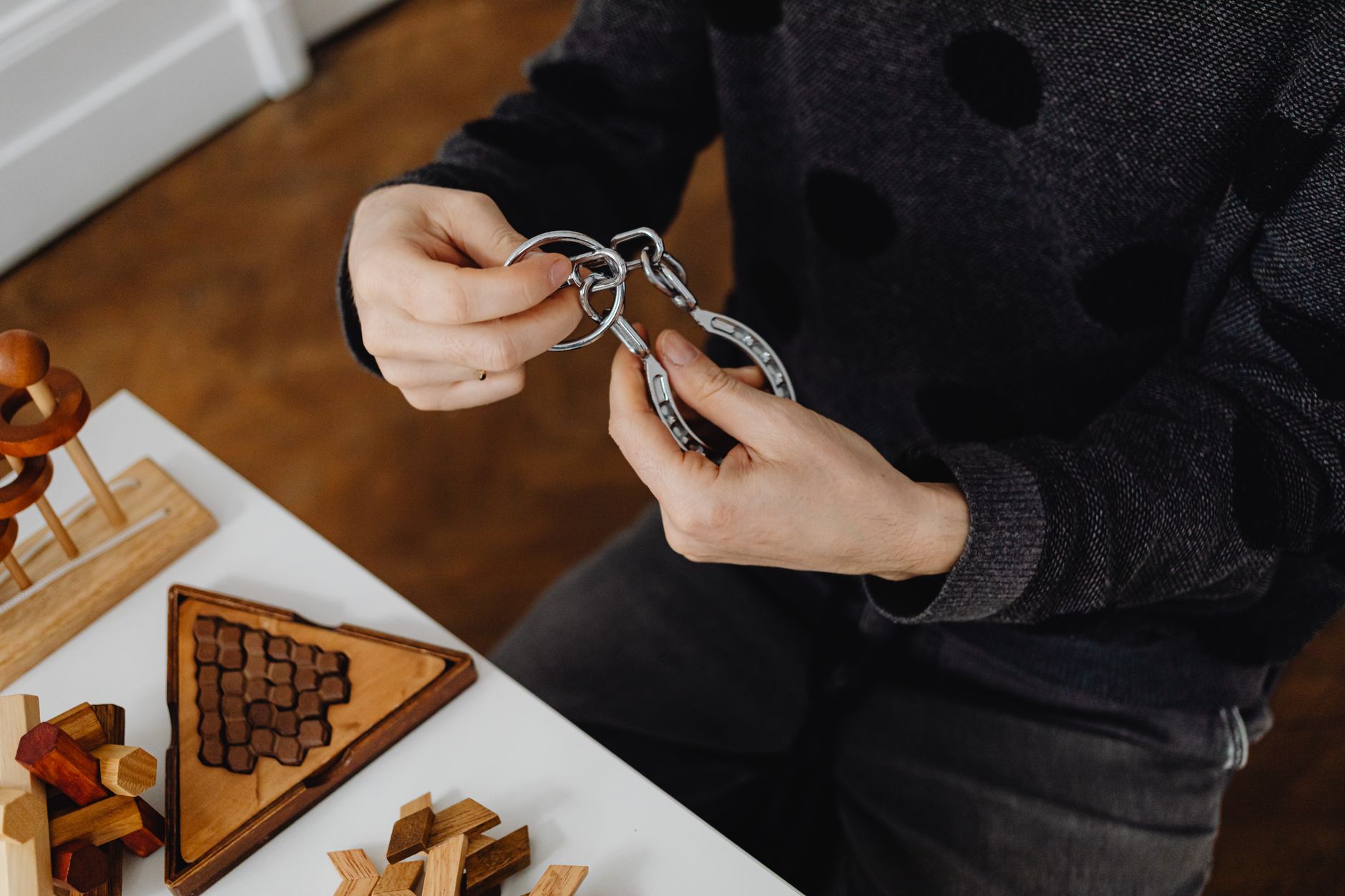 Mains manipulant un casse-tête en bois, jeu de réflexion pour entretenir la mémoire