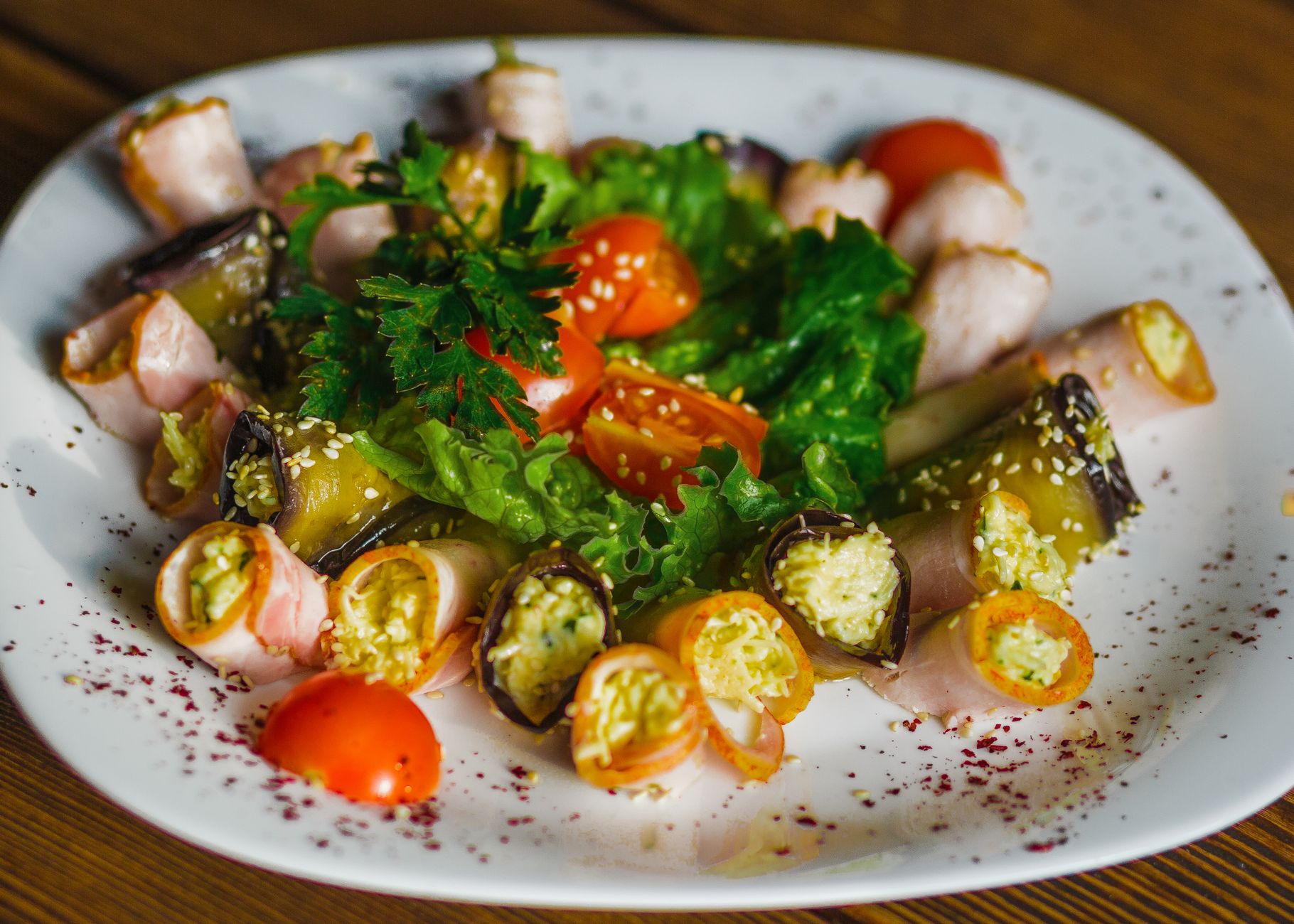 Rouleaux de légumes colorés et jambon avec tomates cerises et laitue.