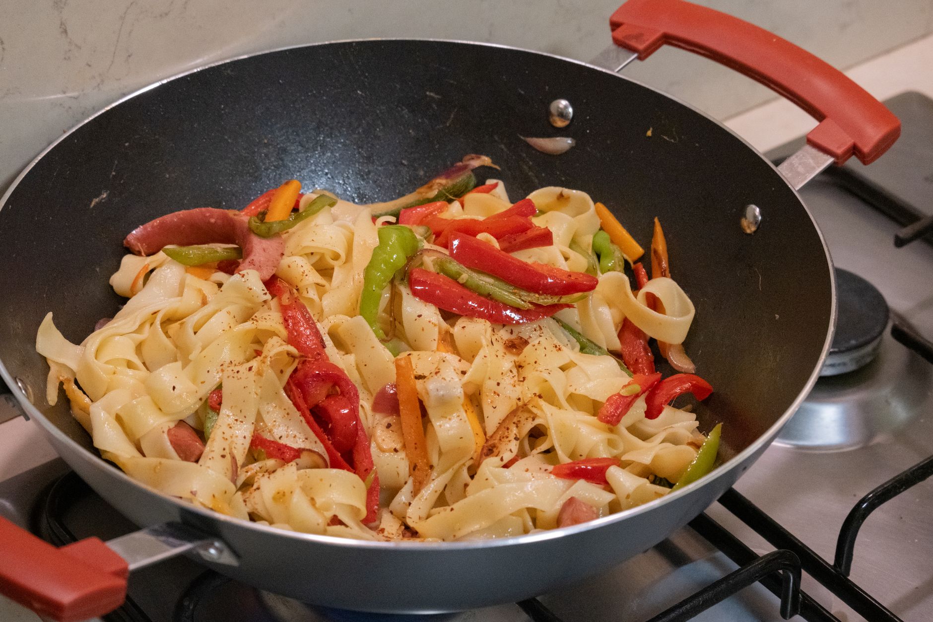 Pâtes aux légumes colorés dans une poêle sur la cuisinière.