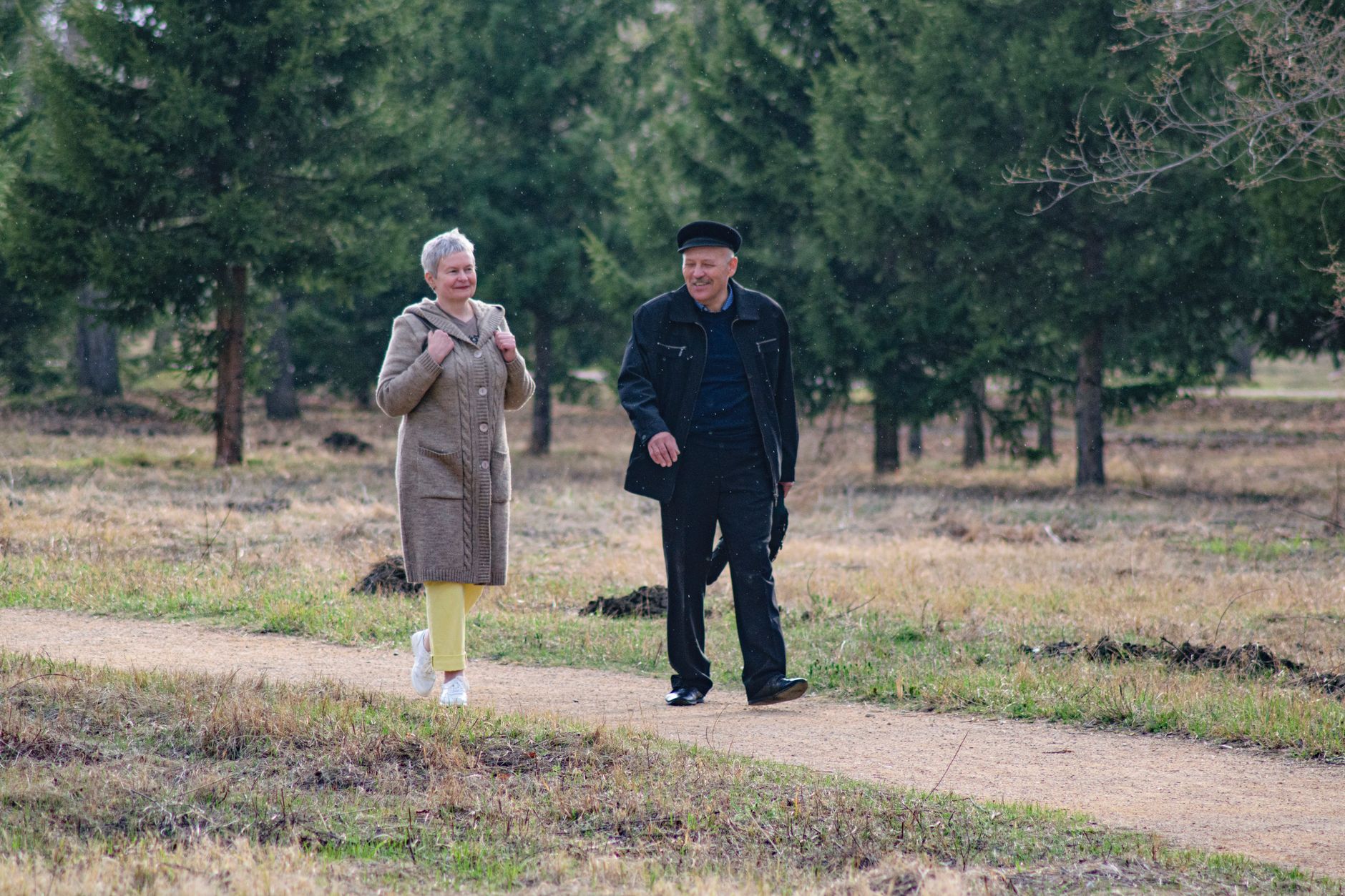 Couple senior heureux se promenant dans un parc au printemps.