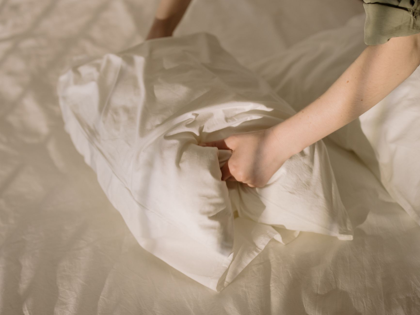 Gros plan de draps blancs propres dans une chambre confortable.
