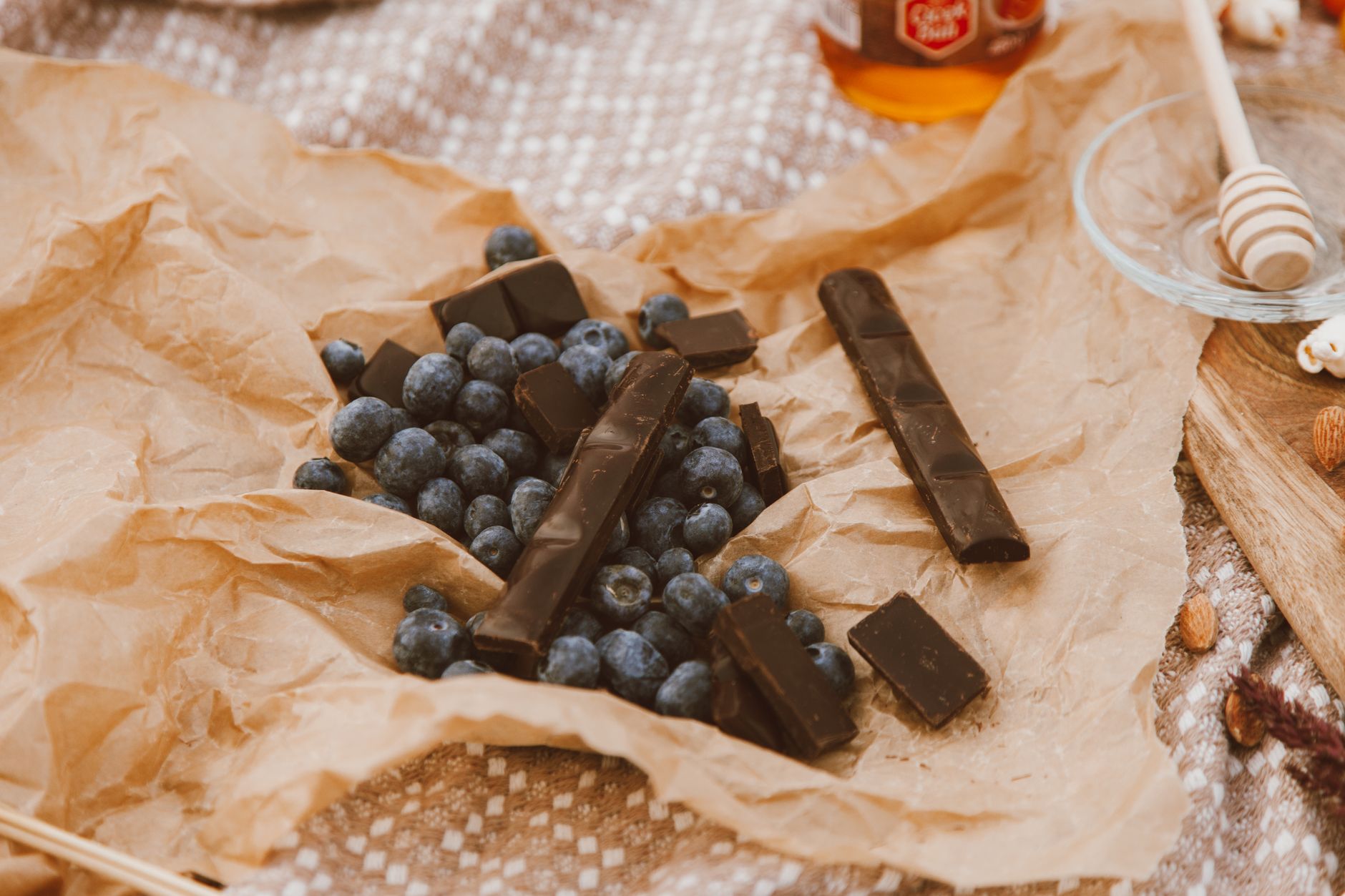 Nature morte artistique de myrtilles et chocolat noir sur papier parchemin.