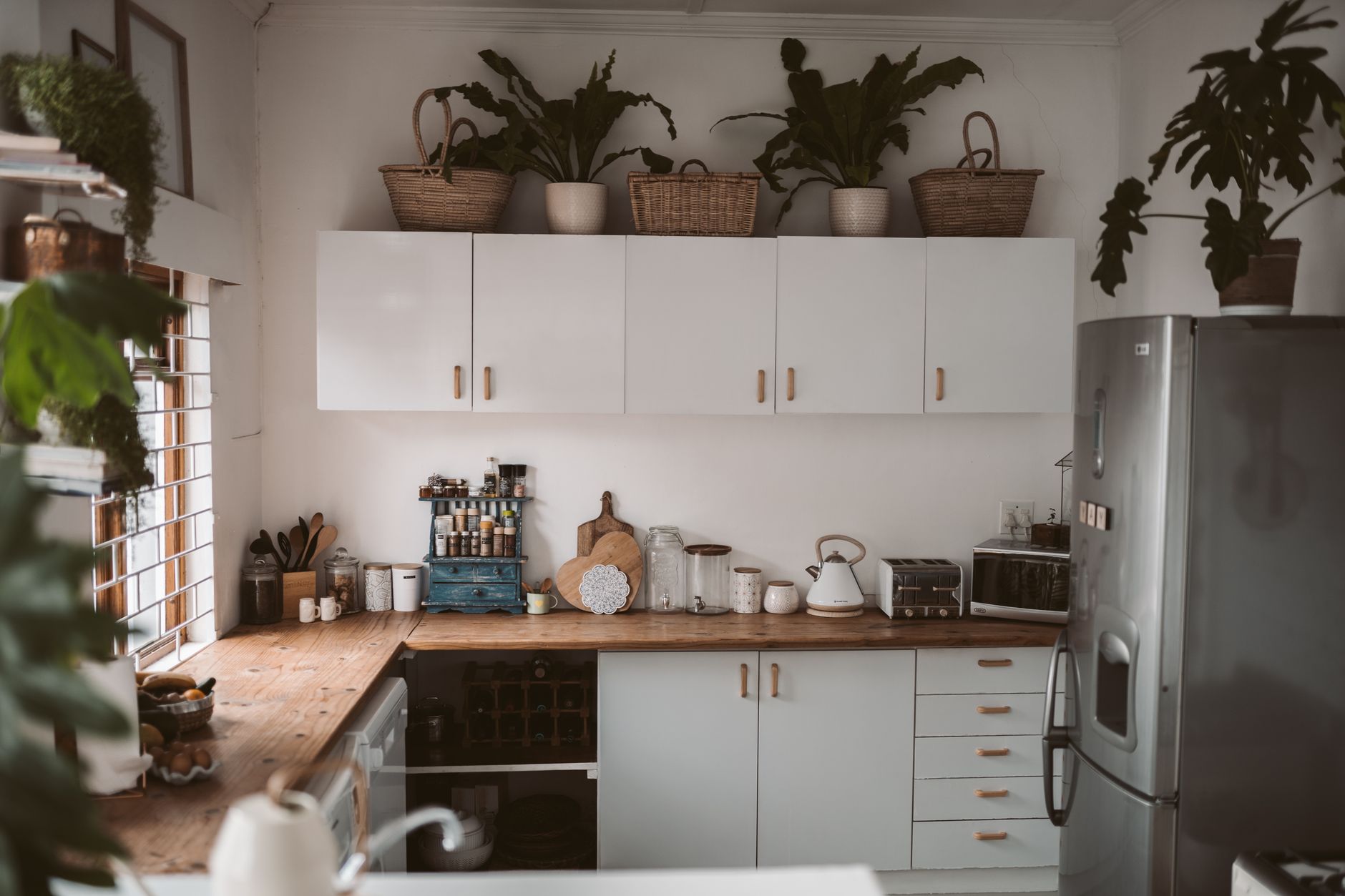 Intérieur de cuisine stylée avec meubles, appareils et plantes d’intérieur.