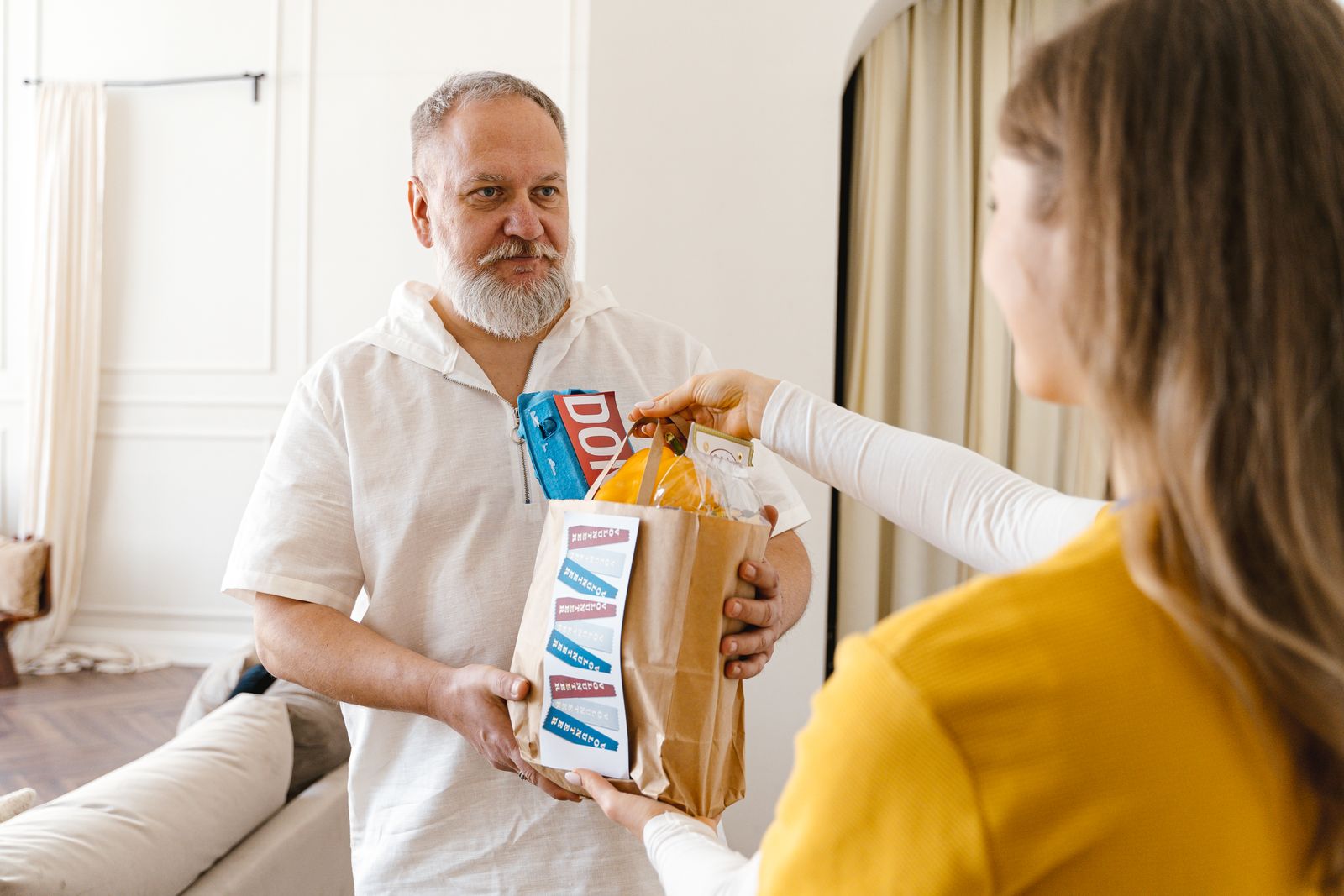 Aide à domicile apportant des courses à un senior
