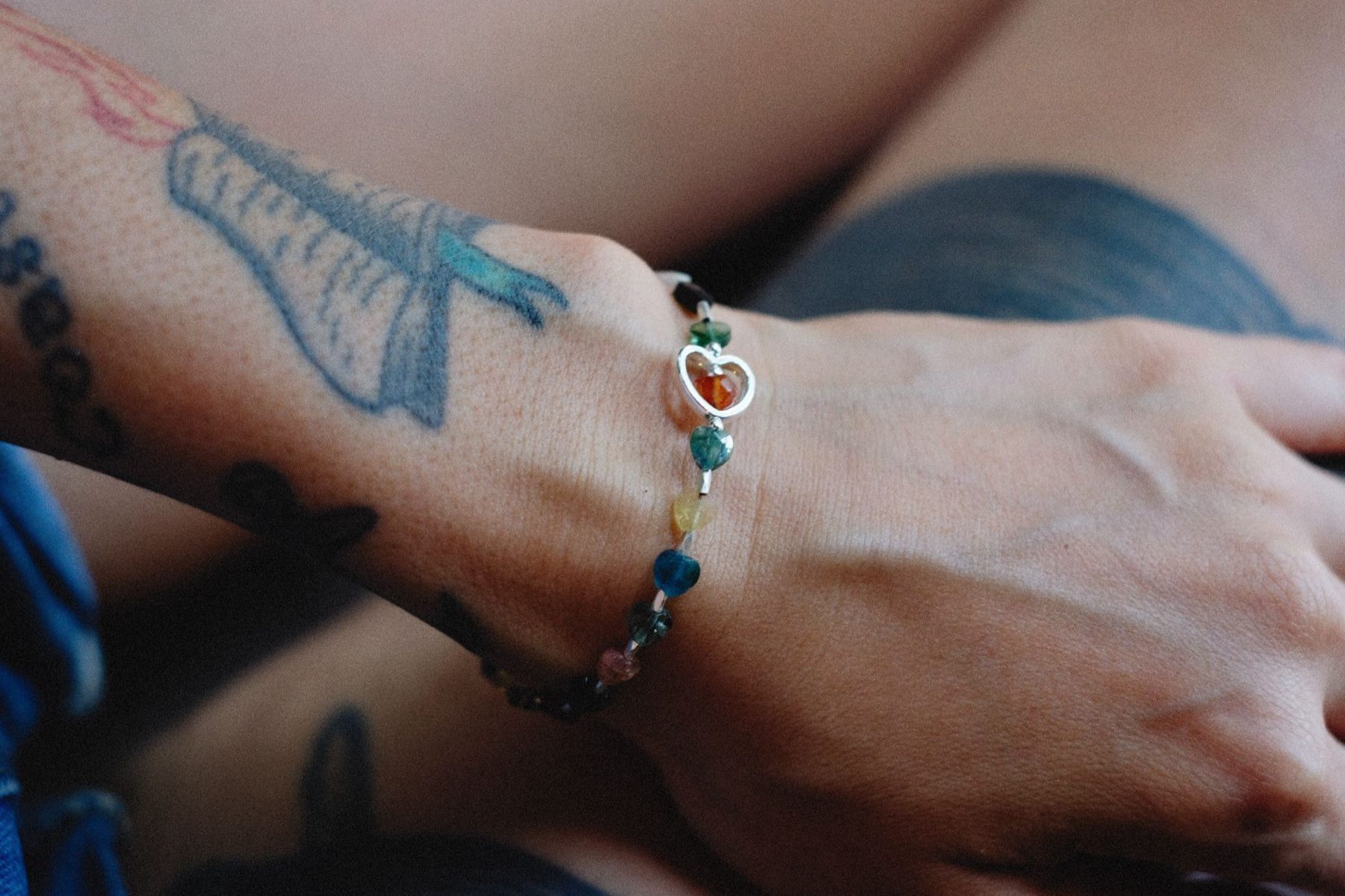 bracelet artisanal en perles de pierres naturelles porté au poignet, gros plan