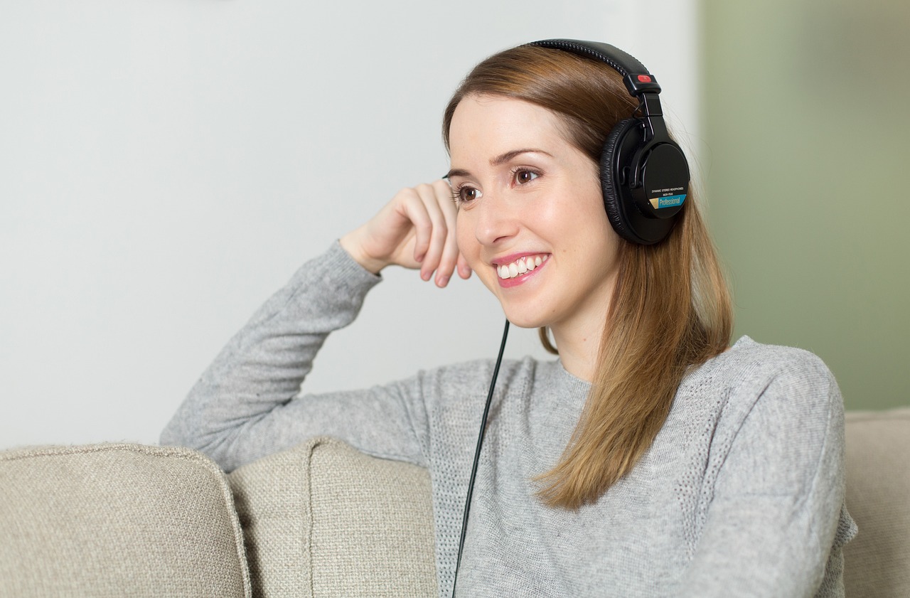 Femme détendue qui écoute de la musique au casque avant de dormir