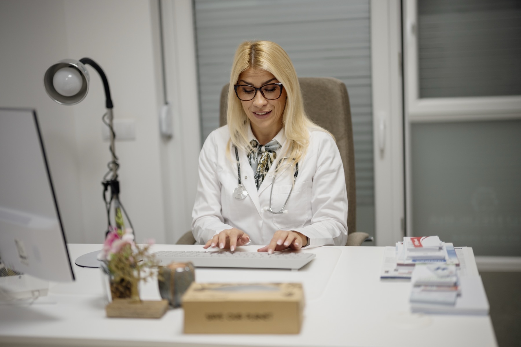 médecin en blouse blanche qui prend des notes pendant une consultation