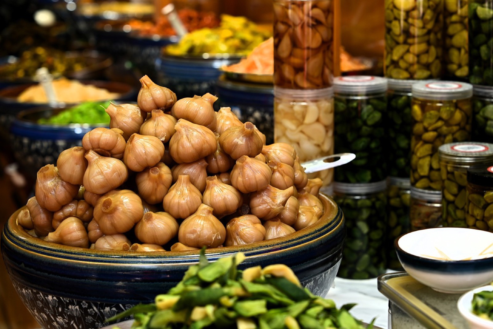 Bocaux de légumes fermentés, dont du kimchi, posés sur une table en bois