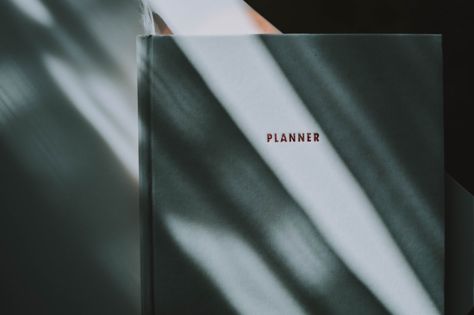Carnet de planning hebdomadaire posé près d'une paire de baskets