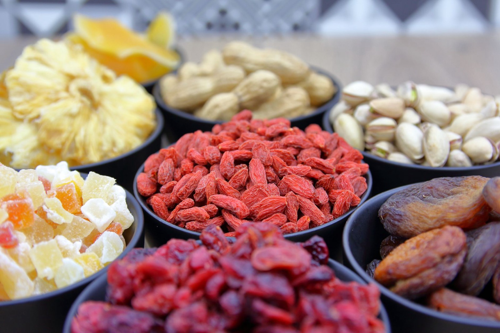 Bol de fruits secs et de fruits posé sur une table, lumière tamisée du soir