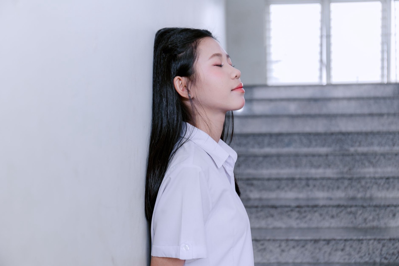 Femme les yeux fermés qui respire calmement avant une réunion
