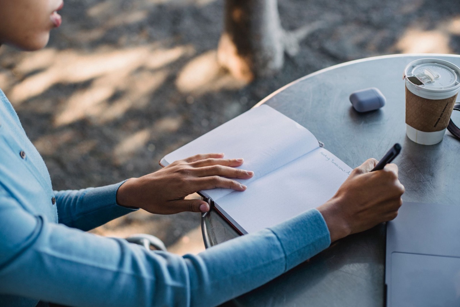 carnet de notes et tasse de café sur un bureau, signe de fatigue au travail
