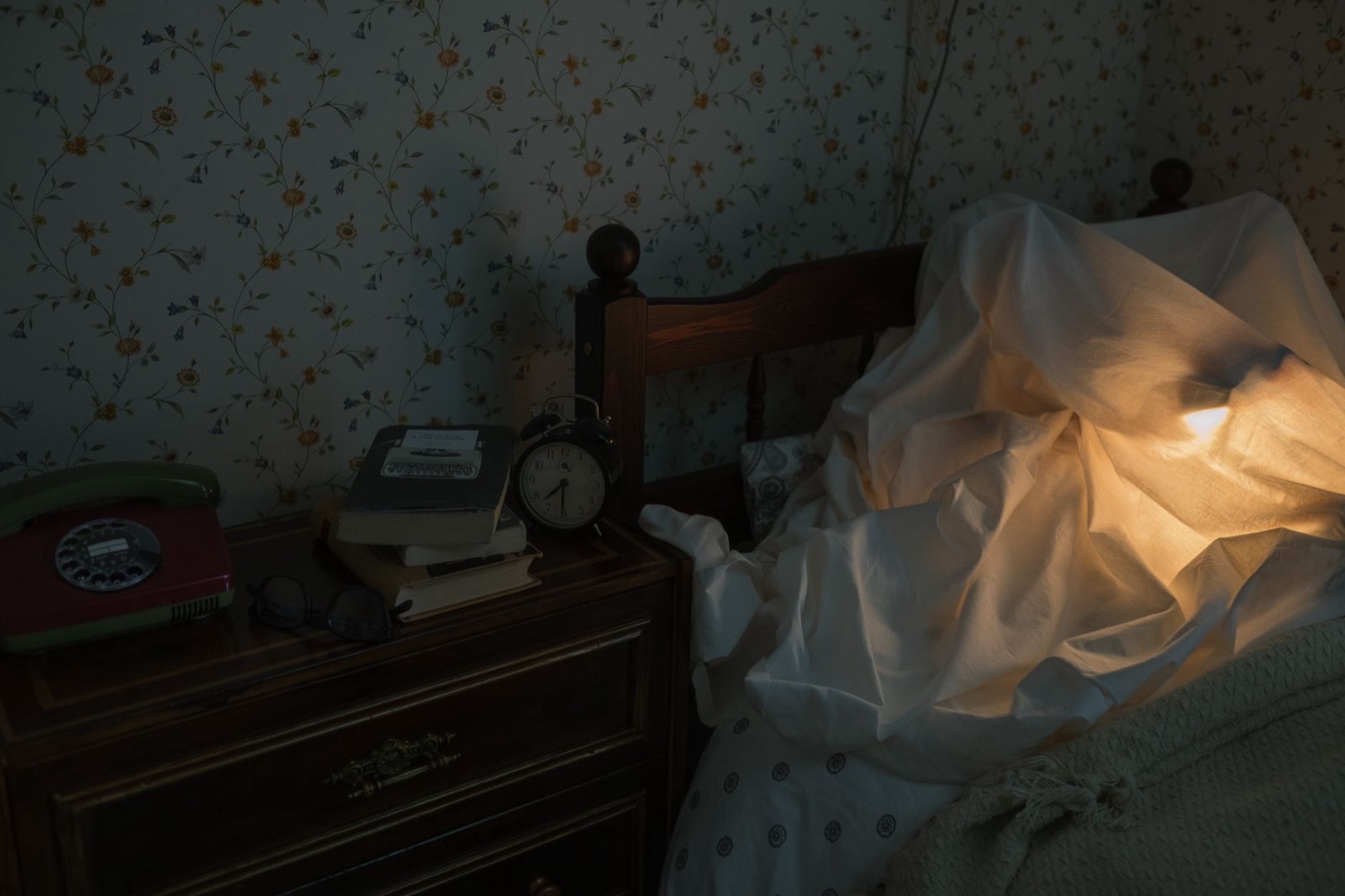 Flacon de spray aux huiles essentielles posé sur une table de nuit, lumière tamisée