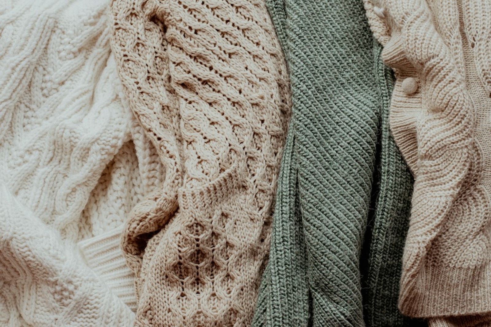 Pulls en laine et en coton pliés et empilés sur une étagère